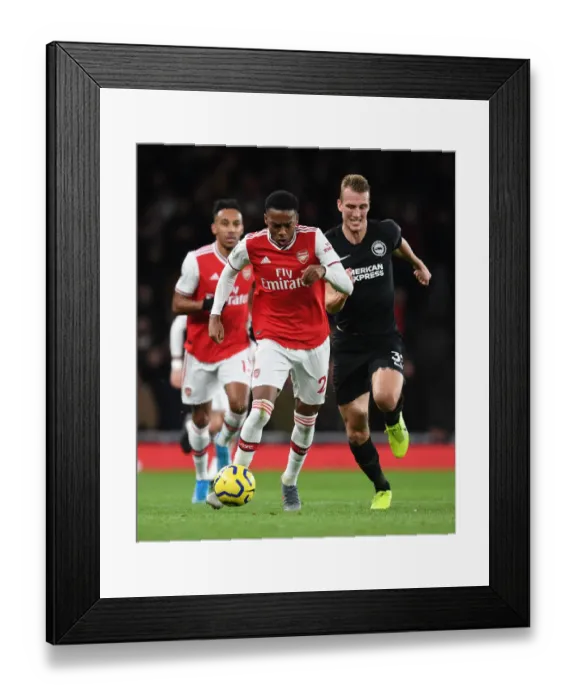 Framed Print : Arsenal's Joe Willock Outmaneuvers Brighton's Dan Burn in Premier League Clash