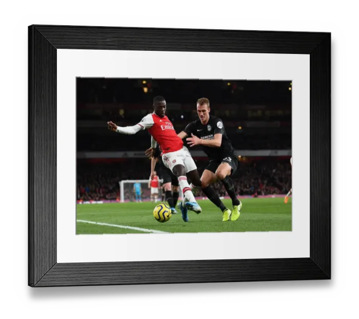 Framed Print : Arsenal's Pepe Faces Off Against Brighton's Burn in Premier League Clash