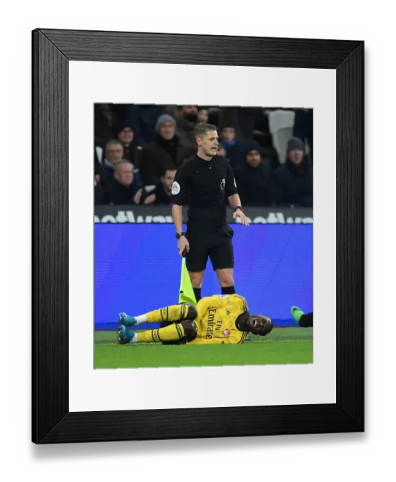 Framed Print : Injured Nicolas Pepe: A Moment of Agony in West Ham United vs Arsenal FC, Premier League