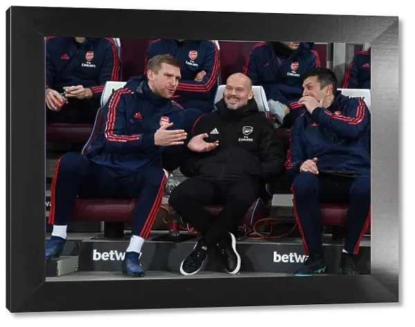 Arsenal Coaches Ljungberg, Mertesacker, and Bibbo Share a Laugh on the Touchline during West Ham Match