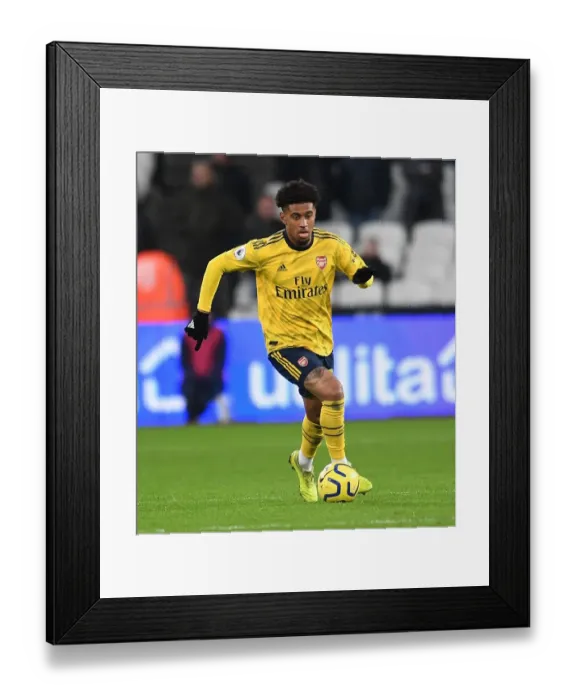 Framed Print : Arsenal's Reiss Nelson Faces Off Against West Ham in Premier League Clash