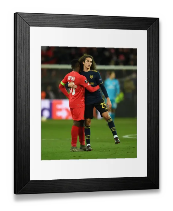 Framed Print : Arsenal's Guendouzi Embraces Mpoku After Standard Liege Clash in Europa League Framed Print : Arsenal's Guendouzi Embraces Mpoku After Standard Liege Clash in Europa League