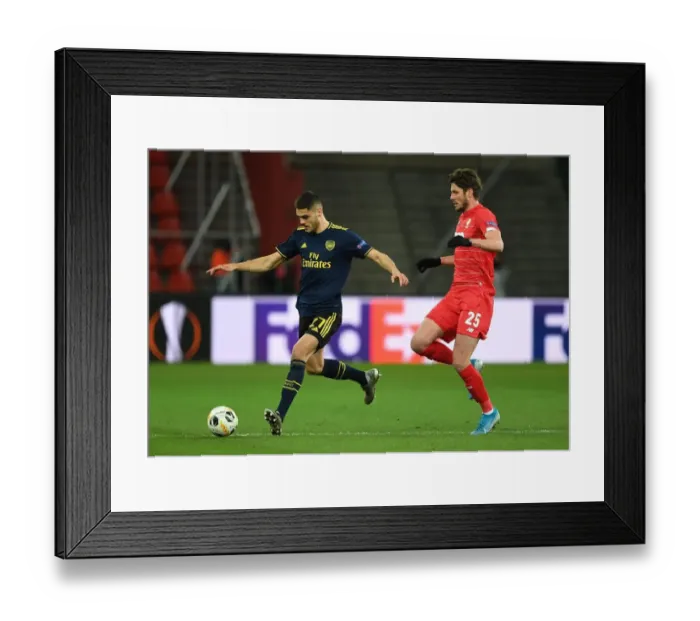 Framed Print : Arsenal's Mavropanos Faces Off Against Standard Liege's Avenatti in Europa League Clash Framed Print : Arsenal's Mavropanos Faces Off Against Standard Liege's Avenatti in Europa League Clash