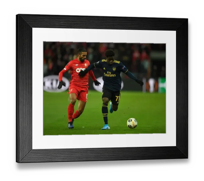Framed Print : Bukayo Saka Faces Off Against Mehdi Carcela in Standard Liege vs. Arsenal UEFA Europa League Clash