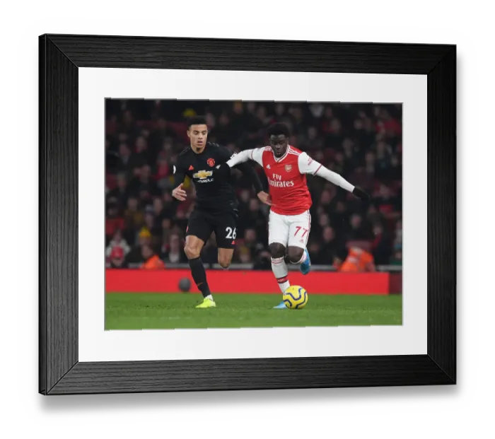 Framed Print : Arsenal's Bukayo Saka Outmaneuvers Manchester United's Mason Greenwood in Premier League Clash