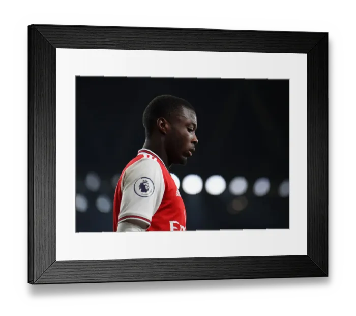 Framed Print : Arsenal's Nicolas Pepe Goes Head-to-Head with Manchester United in Premier League Clash
