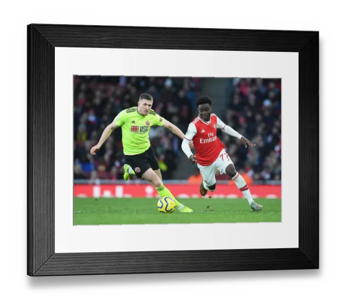 Framed Print : Arsenal's Bukayo Saka Faces Off Against Sheffield United's John Lundstram in Premier League Clash Framed Print : Arsenal's Bukayo Saka Faces Off Against Sheffield United's John Lundstram in Premier League Clash
