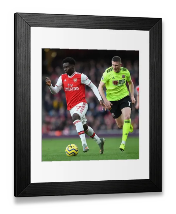 Framed Print : Arsenal's Bukayo Saka Clashes with Sheffield United's John Lundstram in Premier League Showdown Framed Print : Arsenal's Bukayo Saka Clashes with Sheffield United's John Lundstram in Premier League Showdown