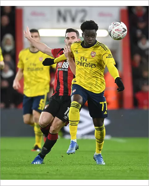 Arsenal's Bukayo Saka Outmaneuvers Lewis Cook in FA Cup Clash