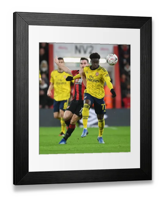 Framed Print : Arsenal's Bukayo Saka Outmaneuvers Lewis Cook in FA Cup Clash