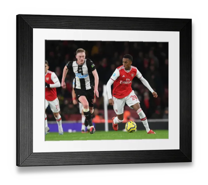 Framed Print : Arsenal's Joe Willock Outmaneuvers Newcastle's Sean Longstaff in Premier League Clash