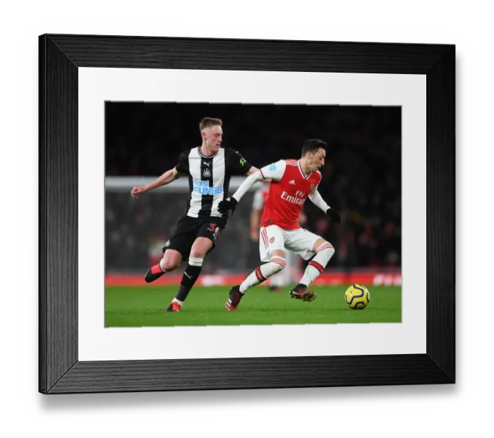 Framed Print : Arsenal's Ozil Clashes with Newcastle's Longstaff in Premier League Showdown
