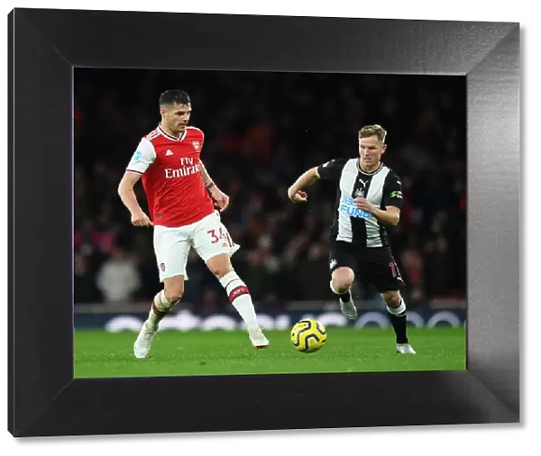 Arsenal's Xhaka Fends Off Newcastle's Ritchie During Premier League Clash
