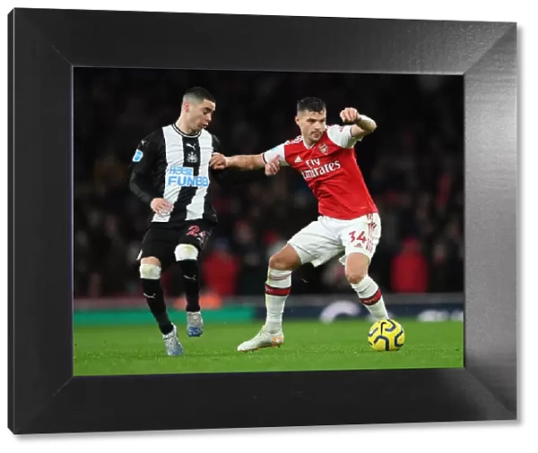 Arsenal's Granit Xhaka Holds Off Newcastle's Miguel Almiron During Premier League Clash