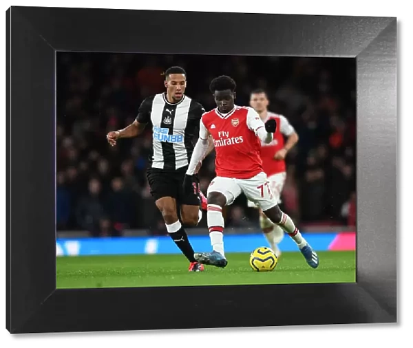 Arsenal's Bukayo Saka Faces Off Against Newcastle's Isaac Hayden in Premier League Clash