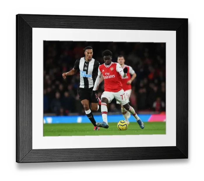 Framed Print : Arsenal's Bukayo Saka Faces Off Against Newcastle's Isaac Hayden in Premier League Clash