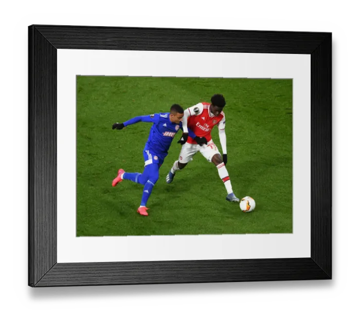 Framed Print : Arsenal's Bukayo Saka Clashes with Olympiacos Bruno Gaspar in Europa League Showdown