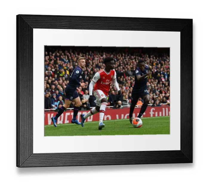 Framed Print : Arsenal's Bukayo Saka Faces Off Against West Ham's Jeremy Ngakia in Premier League Clash