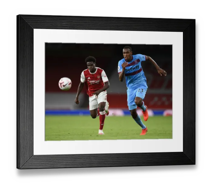 Framed Print : Arsenal's Bukayo Saka Takes on West Ham's Issa Diop in Premier League Clash