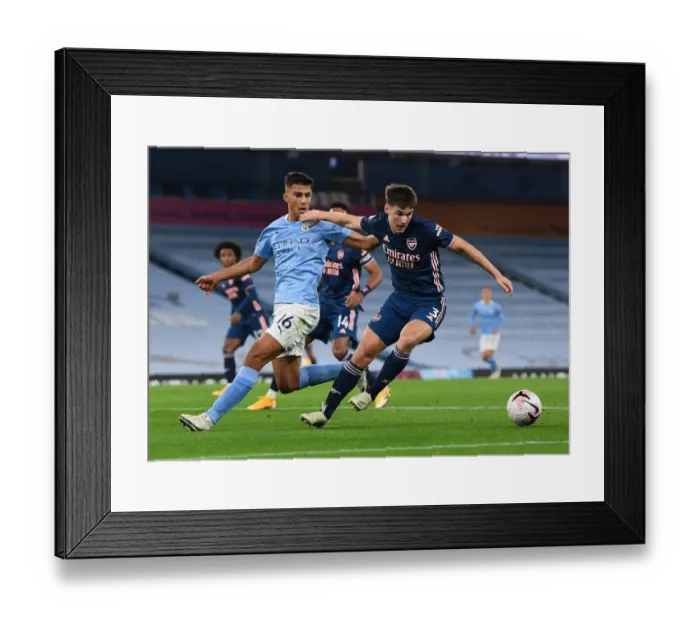 Framed Print : Arsenal's Kieran Tierney Faces Off Against Manchester City's Rodrigo in Premier League Clash