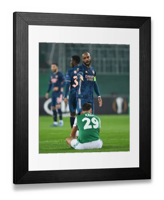 Framed Print : Arsenal's Alex Lacazette Stands Over Injured Rapid Wien Player in Europa League Clash Framed Print : Arsenal's Alex Lacazette Stands Over Injured Rapid Wien Player in Europa League Clash