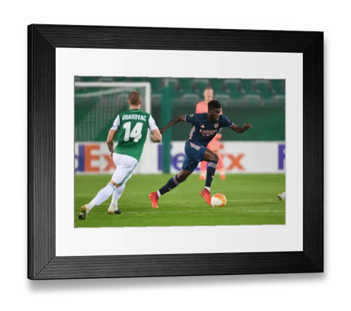 Framed Print : Thomas Partey Breaks Past Rapid Wien's Srdan Grahovac in Arsenal's UEFA Europa League Clash Framed Print : Thomas Partey Breaks Past Rapid Wien's Srdan Grahovac in Arsenal's UEFA Europa League Clash