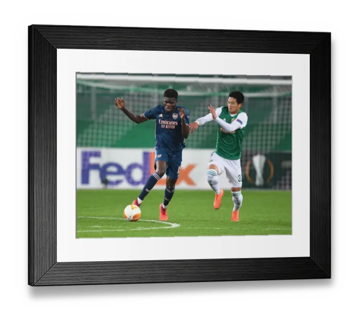 Framed Print : Thomas Partey Breaks Past Rapid Wien's Koya Kitagawa in Arsenal's UEFA Europa League Clash