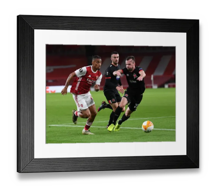 Framed Print : Arsenal's Reiss Nelson Faces Off Against Dundalk's Cameron Dummigan in Empty Emirates Stadium - UEFA Europa League 2020-21