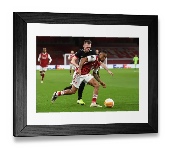 Framed Print : Arsenal's Reiss Nelson Faces Off Against Dundalk's Cameron Dummigan in Empty Emirates Stadium - UEFA Europa League 2020-21