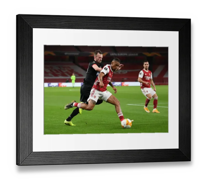 Framed Print : Arsenal's Reiss Nelson Clashes with Dundalk's Cameron Dummigan in Empty Emirates Stadium - UEFA Europa League 2020-21
