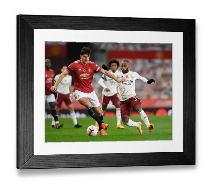 Framed Print : Clash at Old Trafford: Arsenal's Lacazette Pressures Maguire Amid Empty Stands (Manchester United vs Arsenal, 2020-21) Framed Print : Clash at Old Trafford: Arsenal's Lacazette Pressures Maguire Amid Empty Stands (Manchester United vs Arsenal, 2020-21)