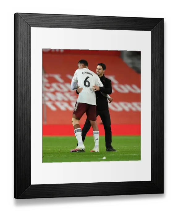 Framed Print : Arsenal's Victory at Old Trafford: Arteta and Gabriel Celebrate Amidst Empty Stands (Manchester United vs Arsenal, 2020-21)