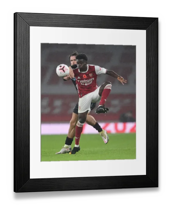 Framed Print : Arsenal vs Aston Villa: Bukayo Saka Fends Off Jack Grealish Pressure in Premier League Clash Framed Print : Arsenal vs Aston Villa: Bukayo Saka Fends Off Jack Grealish Pressure in Premier League Clash