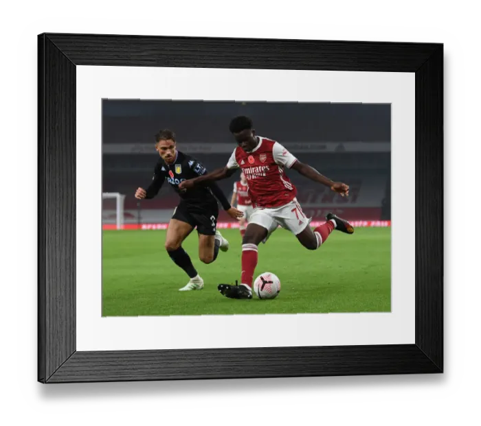 Framed Print : Arsenal's Bukayo Saka Faces Off Against Aston Villa's Matthew Cash in Premier League Clash Framed Print : Arsenal's Bukayo Saka Faces Off Against Aston Villa's Matthew Cash in Premier League Clash