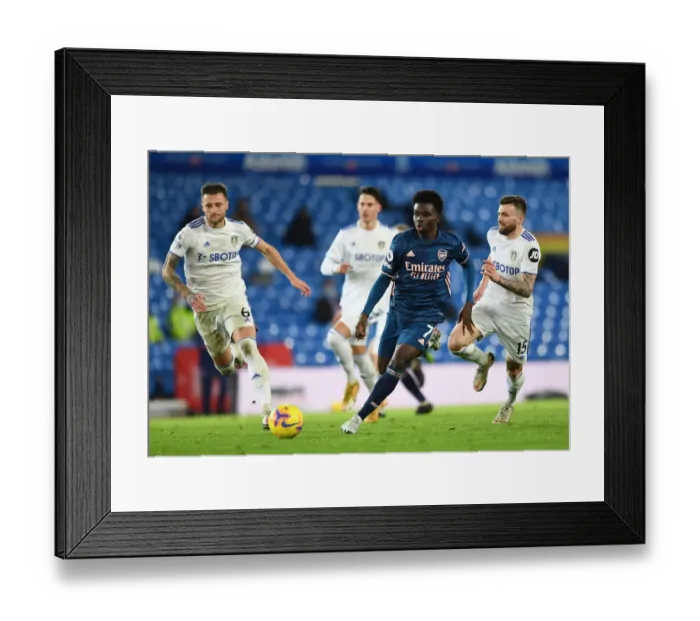 Framed Print : Bukayo Saka Faces Off Against Leeds Duo in Intense Arsenal-Leeds Clash (Premier League 2020-21)