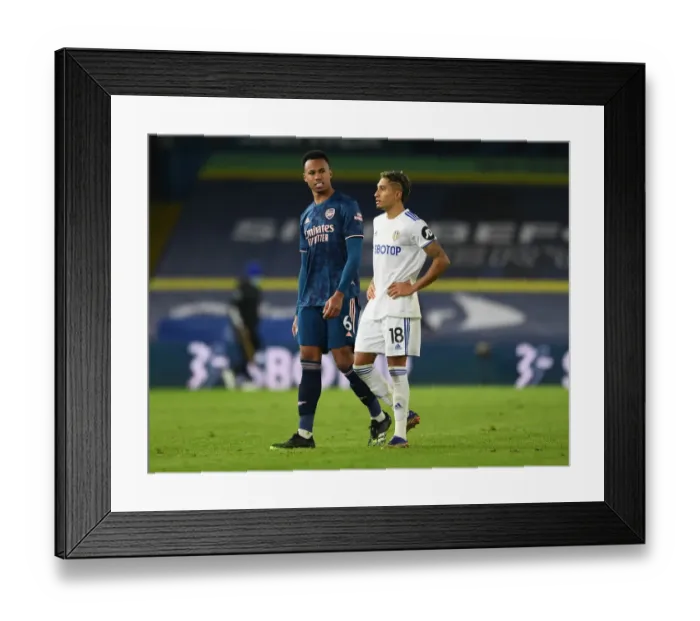 Framed Print : Leeds United vs. Arsenal: Gabriel Magalhaes and Raphinha Share a Moment After Intense Premier League Clash