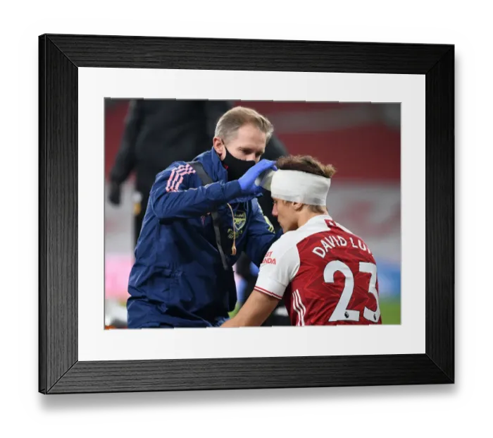 Framed Print : Arsenal's David Luiz Receives Head Injury Treatment Alone at Empty Emirates Stadium (Premier League 2020-21: Arsenal vs. Wolverhampton Wanderers)