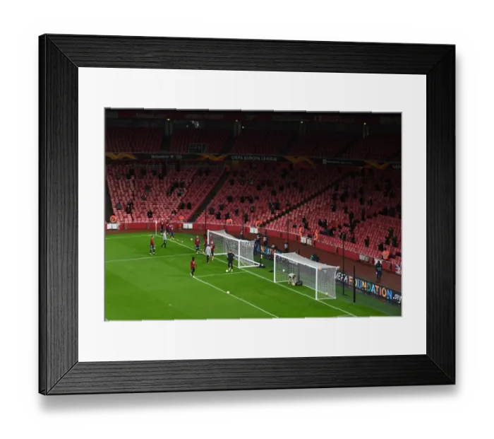 Framed Print : Arsenal vs Rapid Wien at Emptied-Out Emirates Stadium: Fans Watch Team Warm-Up during UEFA Europa League Match Amidst Coronavirus Restrictions (December 2020)