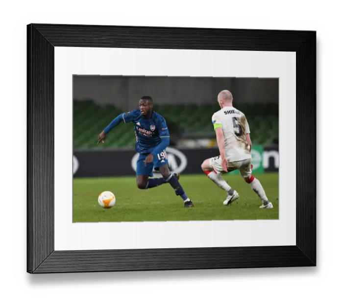 Framed Print : Nicolas Pepe Breaks Past Dundalk's Chris Shields in Arsenal's UEFA Europa League Clash