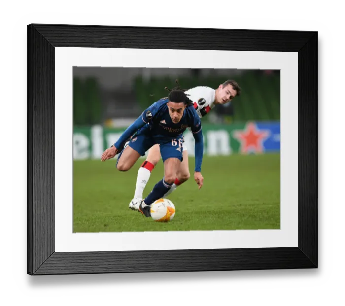 Framed Print : Miguel Azeez Breaks Past Dundalk's James Wynne in Arsenal's UEFA Europa League Victory