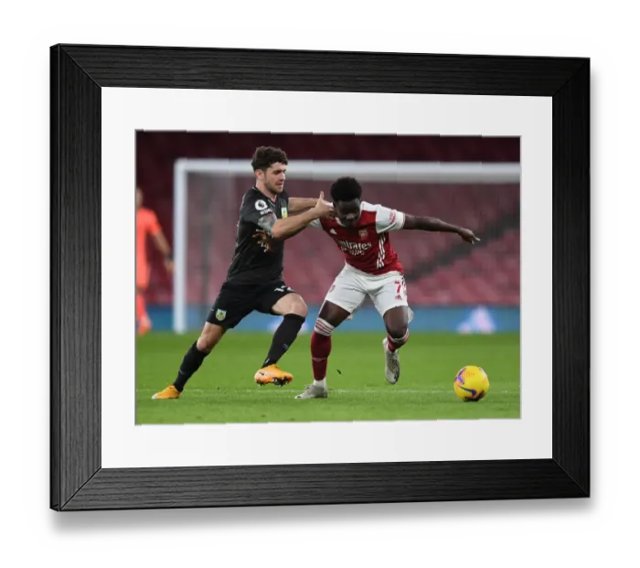 Framed Print : Arsenal's Bukayo Saka Faces Off Against Robbie Brady of Burnley in Premier League Clash