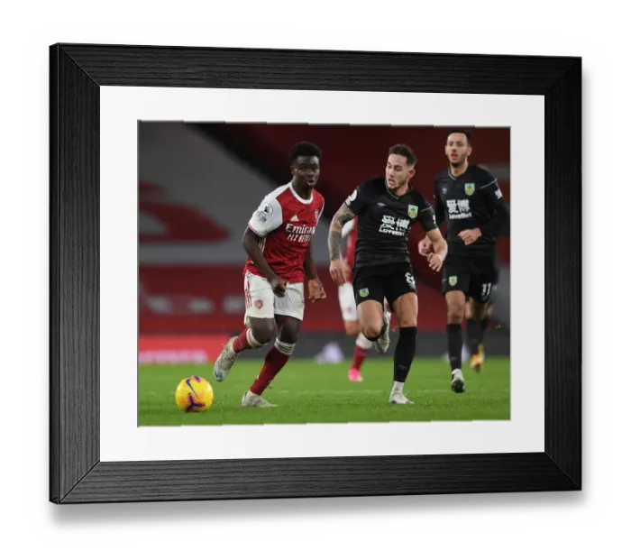 Framed Print : Arsenal's Bukayo Saka Clashes with Burnley's Josh Brownhill in Premier League Showdown