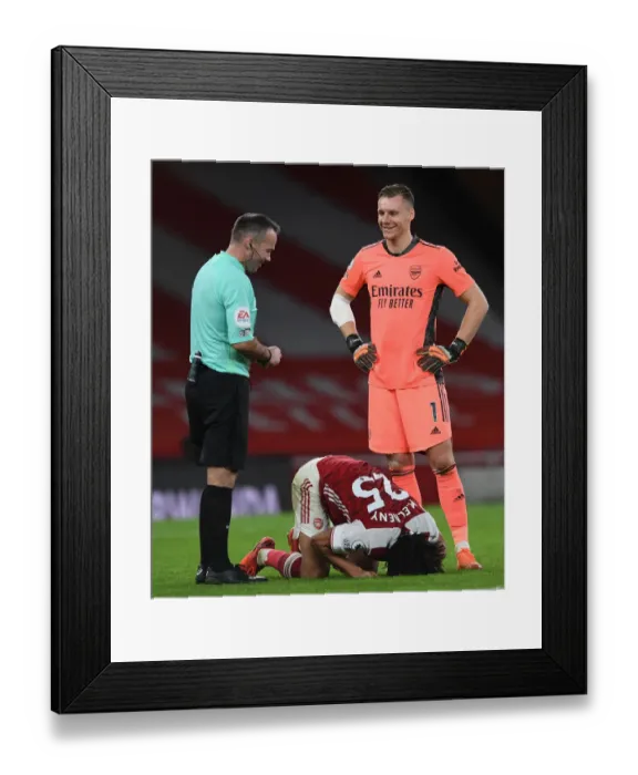 Framed Print : Arsenal's Bernd Leno Shares a Laugh with Referee Paul Tierney Amidst Mohamed Elneny Injury at Emirates Stadium