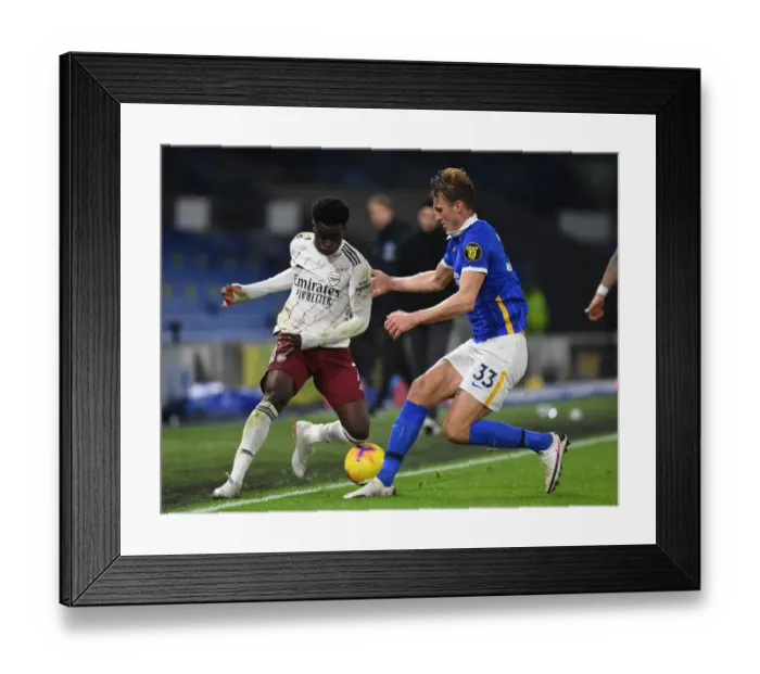 Framed Print : Arsenal's Bukayo Saka vs. Dan Burn: Empty Battle at American Express Community Stadium - Arsenal vs. Brighton & Hove Albion, Premier League 2020-21