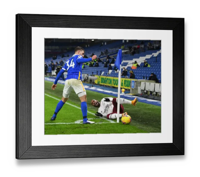 Framed Print : Lacazette Fouls Bissouma: Premier League Showdown Between Arsenal and Brighton at Empty American Express Community Stadium