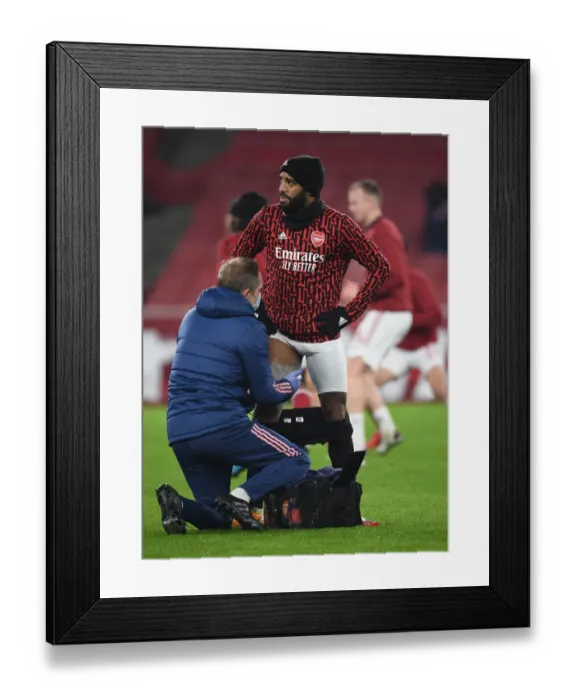 Framed Print : Arsenal's Alexis Lacazette Receives Treatment from Physio Amidst Empty Emirates Stadium (Arsenal v Crystal Palace, Premier League 2021)