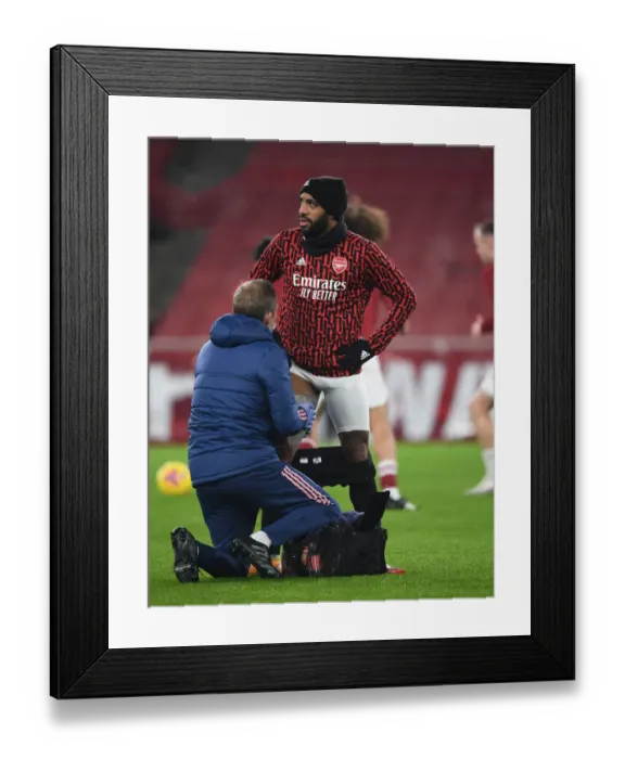 Framed Print : Arsenal's Alex Lacazette Receives Treatment from Physio Amidst Empty Emirates Stadium (Arsenal v Crystal Palace, 2021) Framed Print : Arsenal's Alex Lacazette Receives Treatment from Physio Amidst Empty Emirates Stadium (Arsenal v Crystal Palace, 2021)