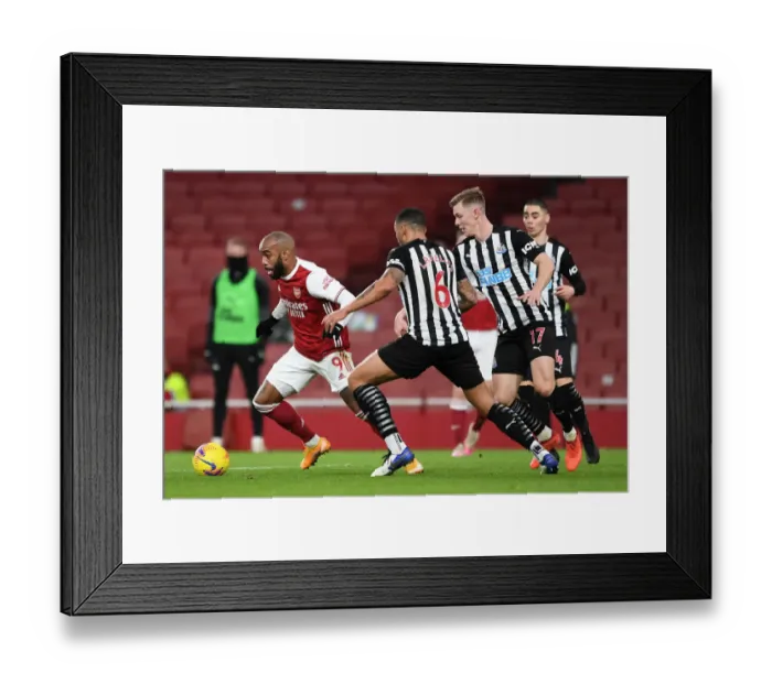 Framed Print : Arsenal vs Newcastle United: Lacazette Faces Off Against Lascelles and Krafth in Empty Emirates Stadium