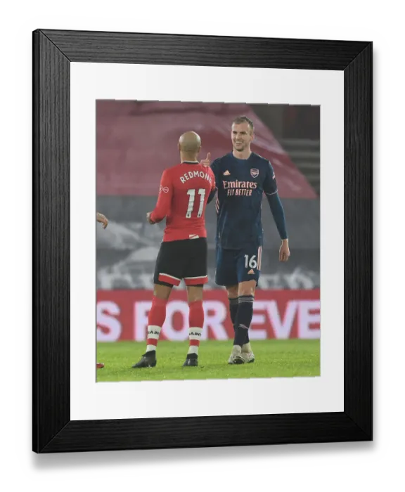 Framed Print : Arsenal's Rob Holding and Southampton's Nathan Redmond Exchange Handshakes in Empty St. Mary's Stadium - Southampton vs Arsenal, 2021 Premier League