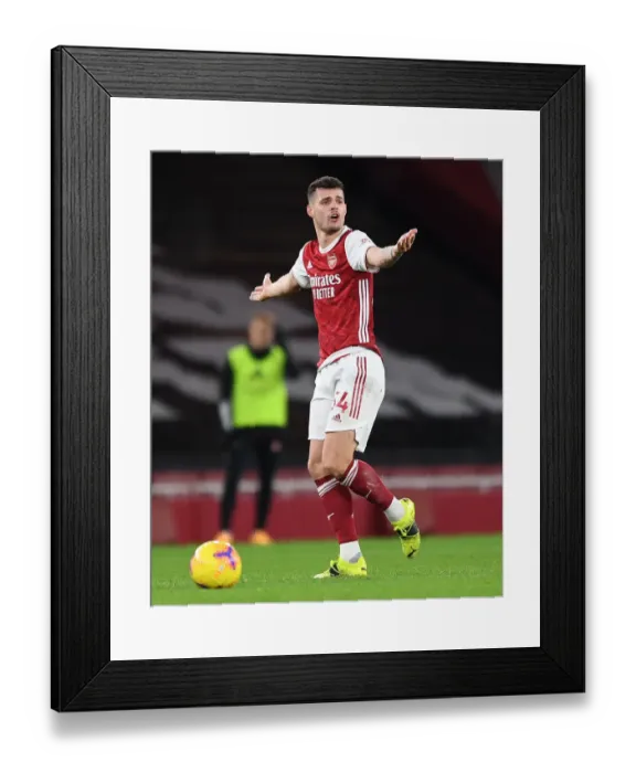 Framed Print : Arsenal's Xhaka Shines in Empty Emirates as Gunners Take on Manchester United (2020-21) Framed Print : Arsenal's Xhaka Shines in Empty Emirates as Gunners Take on Manchester United (2020-21)